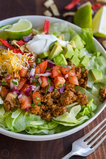 This fresh and easy Taco Salad is loaded with juicy beef on a bed of crisp lettuce with all of your favorite fresh veggies and toppings. (Recipe in comments) | NatashasKitchen.com