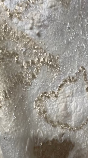 This handmade nuno felted wrap in soft white and vanilla tones is a true piece of wearable art. Crafted from luxurious 18-micron merino wool, delicate silk fibers, and viscose, it brings a blend of warmth, elegance, and weightless texture. 🌿 The design features romantic ruffled edges, subtle golden undertones, and a soft shimmer – perfect for weddings, spring occasions, or styling as an artistic vest or dress overlay. Each wrap is created entirely by hand, using the nuno felting technique – whe