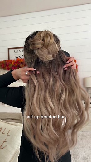 Recreating my viral braided bun, but making it a half up bun 🍂 gather your hair into a half up pony, tie with a clear elastic, braid that pony into a regular 3-strand braid, flip it up and secure with french pins, then flip down and tuck the ends in and secure with more french pins 🧡 would you try this? Wearing @Luxury For Princess in the color ‘frosted blonde,’ use my code EVA! #braidedbun #braidedhairstyles #bunhairstyles #halfuphalfdownhairstyle #easyhairstyles
