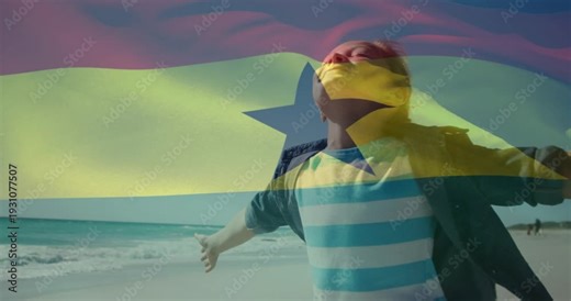 Woman standing arms out tilting head back breeze rippling flag over torso on shore for business