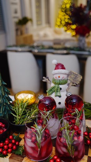How To Make a Christmas Mocktail. Beautiful and elegant Christmas Mocktail. All your need is a nice set of stemless wine glass, some clear glass ornaments, ice, cranberry juice, Rosemary and Voila!! Easy way to impress your guest this holiday season. #mocktailrecipe #christmasmocktail #mocktails #thatchristmasdrink #cranberrymocktails #drinkseason #holidaydrinkrecipes | Nadine Ness