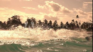 SLOW MOTION, CLOSE UP: Fit woman kiteboarding in Tanzania splashes crystal clear ocean water on a sunny summer evening. Female kitesurfer surfs along the surface of the turquoise sea in Zanzibar.