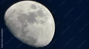 Dark blue sky and silver Moon with visible craters and moving transparent clouds - timelapse. Phase of moon as observed from Northern Hemisphere. Topics: weather, space, science, cosmos, atmosphere