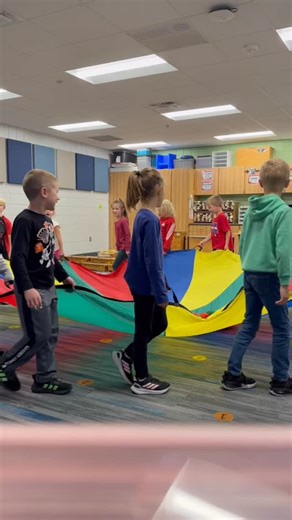 Kindergarteners from Wilson Elementary and first graders from Washington Elementary had a blast in music class using a giant parachute! 🎵🎈 Wilson students listened and responded to music while learning teamwork, while Washington’s first graders sang about collecting apples from the orchard—working together to keep all 25 apples in the parachute “basket”! 🍎👏 #OwatonnaProud | Owatonna Public Schools