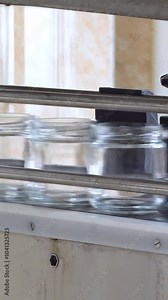 Production of table horseradish with beets. Processing horseradish into food seasoning. Conveyor for packaging table horseradish with red beets into jars. Vertical video.