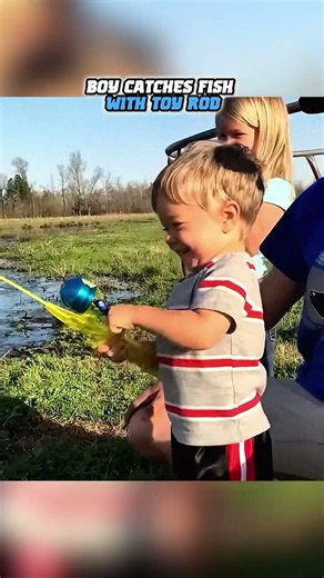 BOY CATCHES FISH WITH TOY ROD