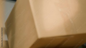 Close up shot of warehouse laborer arranging cardboard boxes full of items ready to be delivered to clients. Diligent employee in stockroom using ladder to put parcels on cabinet shelves