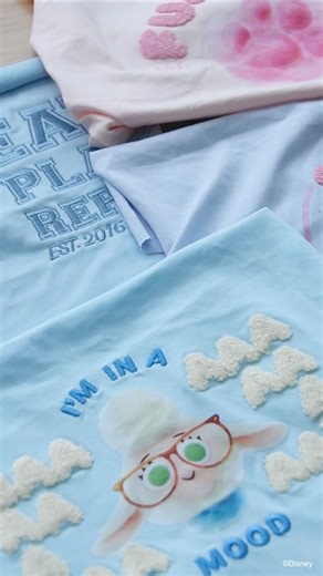 Inside The Elly Studio ✨ Most tees are just prints on fabric. But we want ours to be fun and interactive! That’s why we experiment with little details. We test every swatch - how it looks and feels when you run your fingers across it. For Bellwether, we first tried a furry tuft of hair! But a big fuzzy ball in the middle of the tee? Not quite right. So we made her Baa Baas woolly instead. 🐑 And with our donut design, we changed it up to pink furry frosting and embroidered sprinkles - turning it