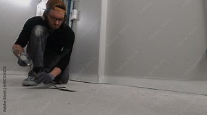 Worker uses a hammer and a chisel to remove the paint residue