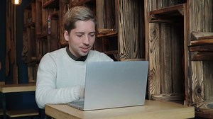 Man typing on a laptop in a cafe - Free Stock Video