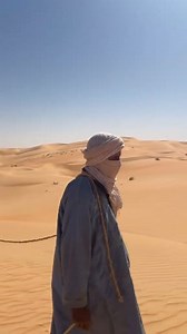 Adrar, Mauritanie 🏜️ une caravane avance lentement dans l’immensité du Sahara, guidée par un homme et ses chameaux. Le silence du désert, le vent chaud, et l’horizon doré créent une scène intemporelle. Ici, chaque pas raconte une histoire ancienne, chaque dune porte un secret. Un voyage tranquille, majestueux, profondément saharien. | Muhammad Hussaini