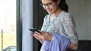 Asian woman chatting online on her smartphone. Online chat has become a prevalent form of communication in an electronically connected society.
