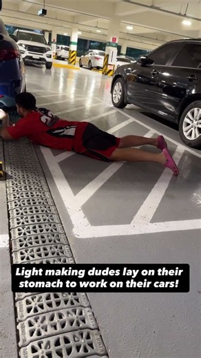 Light skin guys lay on their stomachs and work on their cars
