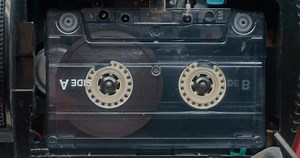 Retro Audio Cassette Tape Playing 80s Mixtapes Sound On Tape Player. Playback of Old Music Using Hi-Fi Vintage Sound System with Nostalgic Atmosphere. Reel-to-Reel Tape Recorder. Macro Close Up.