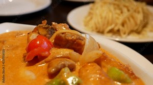 The motion of curry chicken and fried noodles on a table inside Chinese restaurant with 4k resolution