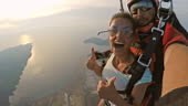 Point of view shot of a woman enjoying her first skydive attached to...