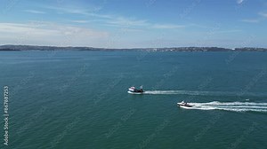 Brixham, Torbay, South Devon, England: DRONE VIEWS: A fishing trawler and motorboat sail towards the harbour. Brixham is a both a fishing port and a popular English holiday destination.