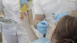 Woman visit dental clinic. Dentist check and select the color of the teeth.