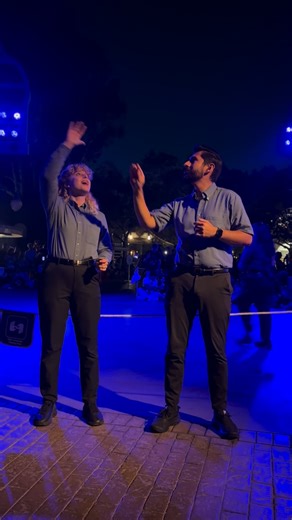 Signs For Humanity on Instagram: "Everyone deserves to enjoy the show! #disneyland #disneyland #fun VD: Two sign language interpreters stand side by side at the Paint theParade. Both wear blue collared shirts and black pants. On the left is a white woman with curly blond hair, and on the right is a brown man with short dark hair. They’re interpreting a song together with energy and emotion, signing in sync with the music and lights around them."