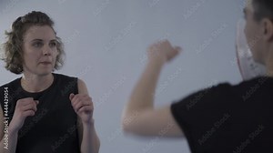 Personal training for women and coach martial art taekwondo during private workout. Two sports women training taekwondo punches boxing paw, use punching mitt. Woman fighter practicing punches.