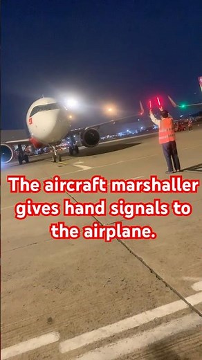 The aircraft marshaller gives hand signals to the airplane. #viral #aviation #short #marshaller