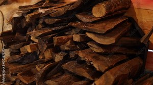 Two piles of wood and logs sitting side by side.