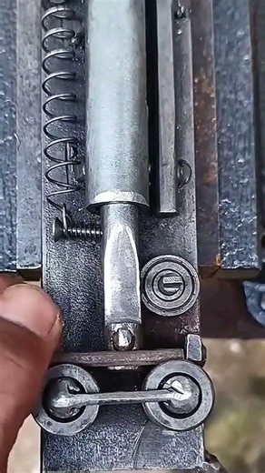 bending a small steel rod using a custom metal tool to create a perfectly curved link shape