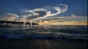 A female triathlete silhouette emerges from the water after the swimming leg of a triathlon race