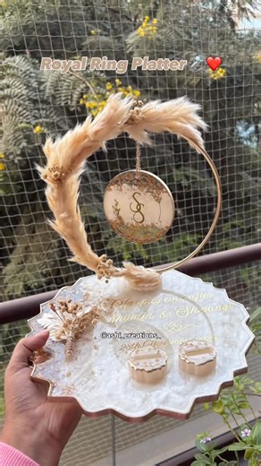 Wedding | Resin | Return Gifts✨ on Instagram: "Not just an engagement ring platter, but a keepsake designed to stay with you forever 🤍✨ Crafted in off-white with soft golden accents, personalized with names, date, and initials, and thoughtfully created to be reused even after the celebration. The floral hoop is detachable, while the base transforms into a beautiful photo frame with the metal stand we provide — because your special moments deserve more than one day of spotlight. Planning your bi
