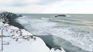 Incredible beautiful landscapes in the south of Iceland. Ocean wawes are breaking on the shores of a black beach. Basalt rocks