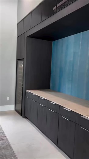 Modern elegance meets custom functionality ✨ This built-in unit was fully designed and fabricated for a high-end residential space, combining clean lines, concealed storage, and seamless technology integration. Project details 👇 ✔️ Dark-oak tone cabinetry for a sophisticated, contemporary look ✔️ Built-in TV panel for entertainment social use ✔️ Integrated wine cooler with bottle display storage ✔️ Stone-top counter designed for service decor styling ✔️ Open upper niches adding architectural di