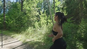 Follow-up Shot of Young Athlete Woman Running Fast down the Road, Training Hard, Getting Ready for Race Competition or Marathon. Fit Girl in Black Sportswear Jogging At Dawn along the Green Fields.