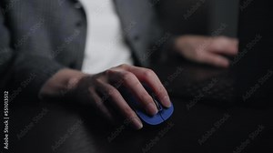 Scene of an anonymous person using a computer in a dark room.