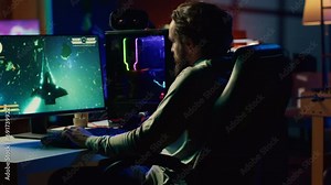 Happy man having fun by using gaming keyboard to fly spaceship in SF videogame. Cheerful gamer using powerful PC and computer peripherals to play game, entertaining himself