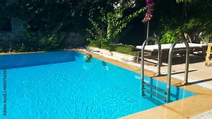 A tranquil 4K video capturing a calm swimming pool with gentle waves on the blue water surface, creating a serene and relaxing atmosphere