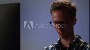 Computer programmer talking close-up, developing new application. Digital software. Man specialist coding on computer, wearing earphones. Web design. Information technology, IT business.