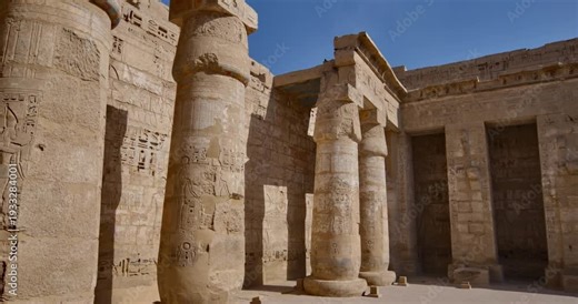 Medinet Habu temple painted ceiling with vulture goddess Nekhbet and hieroglyphs in red orange colors in Luxor Egypt, ancient Egyptian astronomical decorations and cartouches .