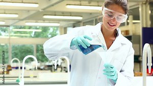 Pretty science student pouring chemical through funnel