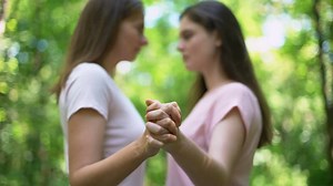 Close up LGBTQ lesbian or friend holding hands and connecting together with love and good moment.Happiness LGBTQ lesbian couple female hold hands walking together with confidence and romance