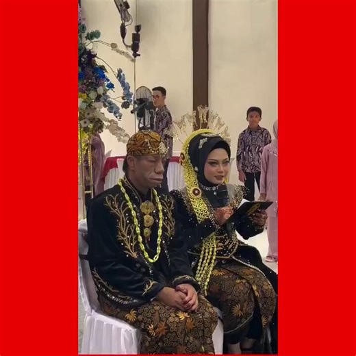 A wedding ceremony in Indonesia with traditional clothing, where the bride recites a love poem to the groom after neighbors had mocked his appearance.