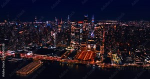 Revealing scenery of huge luminous metropolis as the drone rises up. Top view of night New York, US from above the East River.