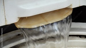 Loading of bed linen and clothes in the washing machine. The water for washing is poured.