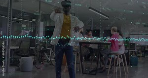 VR user donning headset and manipulating floating data points in open-plan office for tech demo