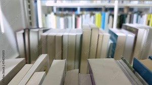 Open book with fanned pages. Stack of hardback paper books on wooden bookshelves. Library bookcase in a row. Books stacking. Back to school. Education, reading moving forward along shelves