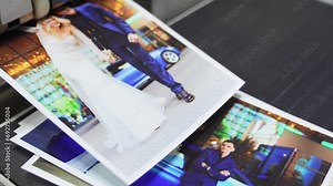 The process of printing wedding photos on a printer in a darkroom.