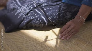 Asian woman's hand holding a spool of cotton yarn, rural culture life in Thailand.
