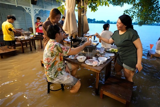 Flooded restaurant becomes surprise tourist attraction as fish swim around diners