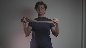 A woman puts on a compression sleeve on her arm to support vein health and prevent thrombosis. Compression helps improve circulation, reducing the risk of blood clots, varicose veins, and embolism.