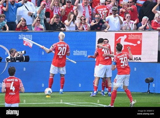 25 April 2026, Rhineland-Palatinate, Mainz: Soccer, Men: Bundesliga, FSV Mainz 05 - Bayern Munich, Matchday 31, Mewa Arena. Paul Nebel (1. FSV Mainz 05) and Nadiem Amiri (1. FSV Mainz 05) celebrate with their teammates after scoring to make it 2-0. Photo: Torsten Silz/dpa - IMPORTANT NOTE: In accordance with the regulations of the DFL German Football League and the DFB German Football Association, it is prohibited to utilize or have utilized photographs taken in the stadium and/or of the match i