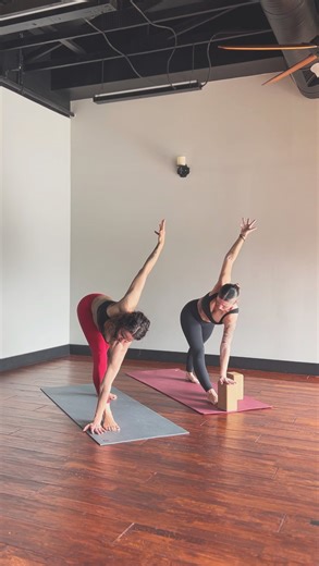 Yoga Nyla on Instagram: "One sequence, two ways. Same sequence. Different choices. An example of how you can dial your physical yoga practice up or down—without changing the poses. 🔴 Diana (red pants): dialing up ⚫ Cassey (black pants): dialing down Downward Facing Dog → Step Through • Diana lifts into Three-Legged Dog before stepping forward • Cassey guides her knees onto her mat and steps her right foot through Pyramid • Diana folds deeply with hands on the mat • Cassey uses blocks to bring t